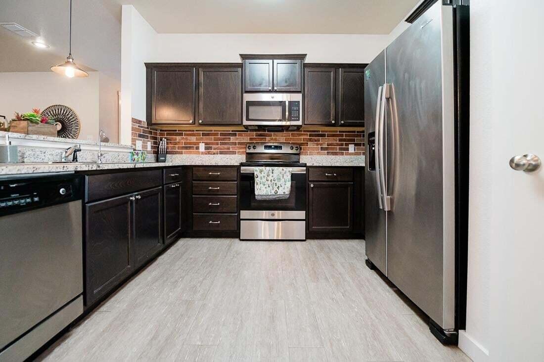 2118 9th Street Lubbock, TX 79401 - Photo 13 of 28 a kitchen with stainless steel appliances granite countertop a refrigerator and a stove top oven