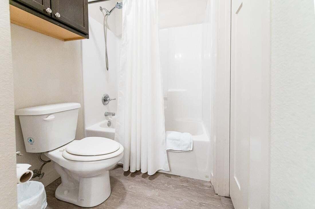 2118 9th Street Lubbock, TX 79401 - Photo 18 of 28 a white toilet sitting next to a shower