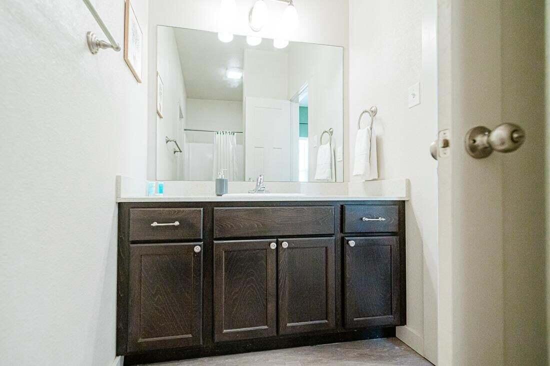 2118 9th Street Lubbock, TX 79401 - Photo 23 of 28 a bathroom with a sink vanity and a mirror