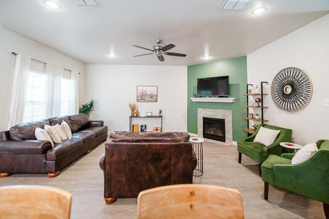 2118 9th Street Lubbock, TX 79401 - Photo 6 of 28 a living room with furniture a flat screen tv and a fireplace