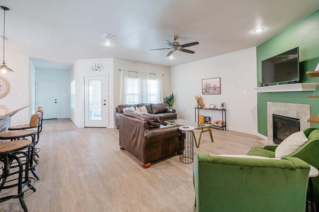2118 9th Street Lubbock, TX 79401 - Photo 7 of 28 a living room with furniture a flat screen tv and a fireplace