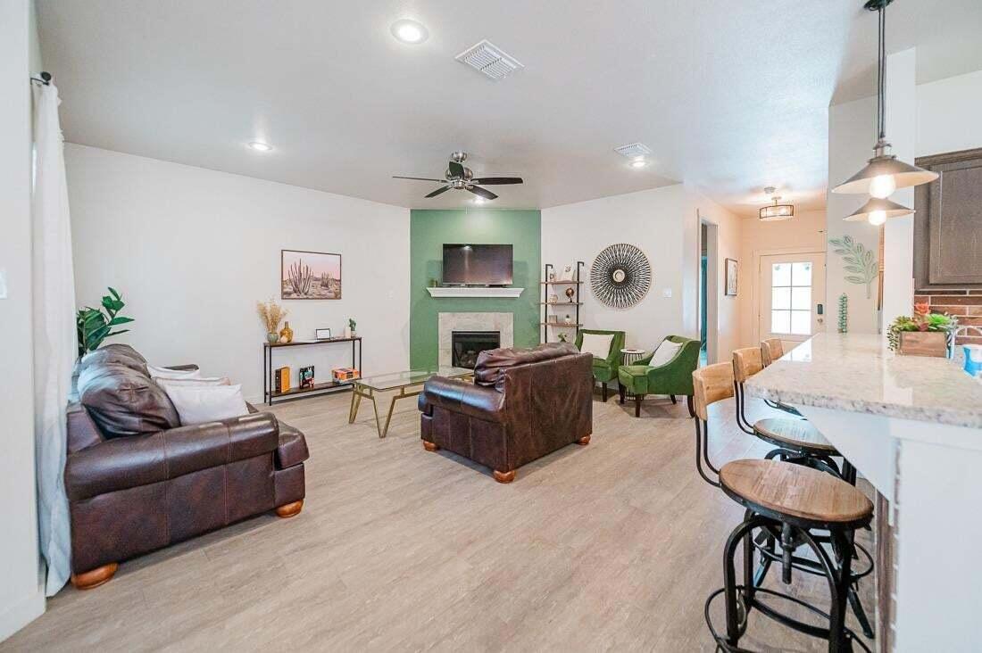 2118 9th Street Lubbock, TX 79401 - Photo 8 of 28 a living room with furniture kitchen view and a wooden floor