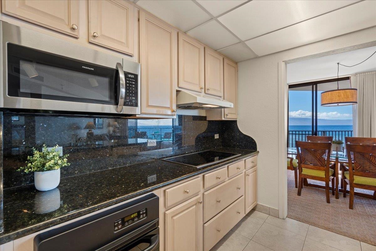 3445 Lower Honoapiilani Road, Unit 701 Lahaina, HI 96761 - Photo 13 of 40 a kitchen with stainless steel appliances kitchen island granite countertop a stove a sink and a microwave
