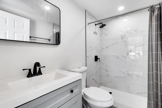 a bathroom with a sink a toilet and a mirror