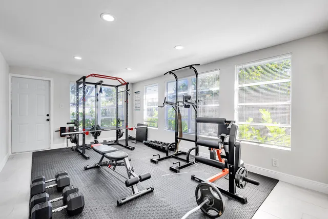 a living room with furniture gym equipment and a large window
