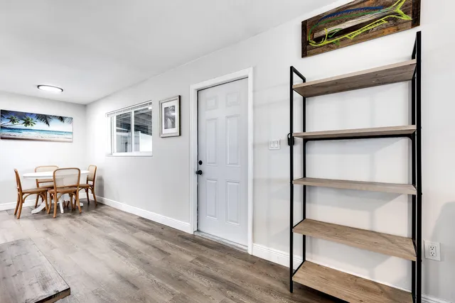 a view of an empty room with furniture and a window