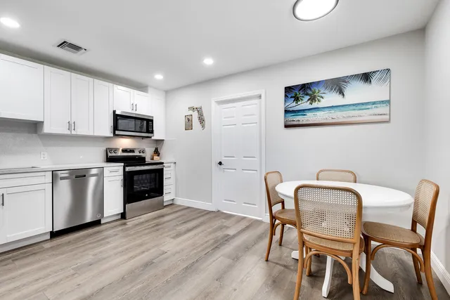 a kitchen with granite countertop cabinets a dining table and chairs