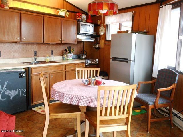 105 Ridge Road Hawley, PA 18428 - Photo 3 of 41 a kitchen with stainless steel appliances granite countertop a dining table chairs and a refrigerator