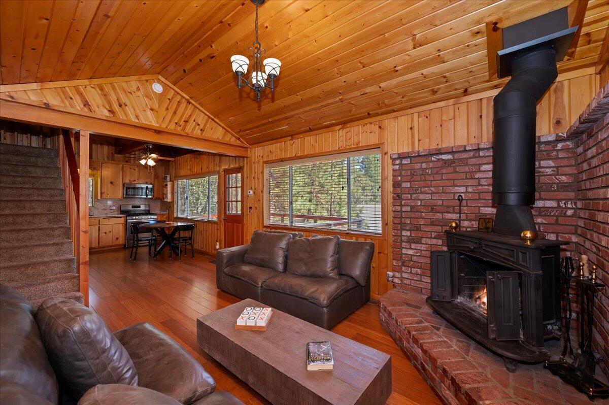 39187 Arapahoe Road Fawnskin, CA 92333 - Photo 19 of 33 a living room with furniture a fireplace and a dining table