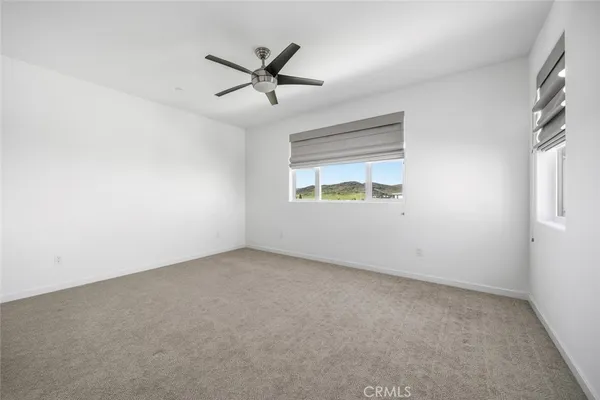 an empty room with a window and a fan