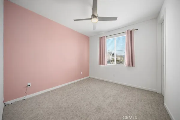an empty room with windows and fan
