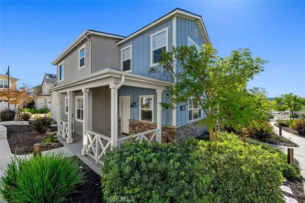 a front view of a house with porch yard outdoor seating and green space