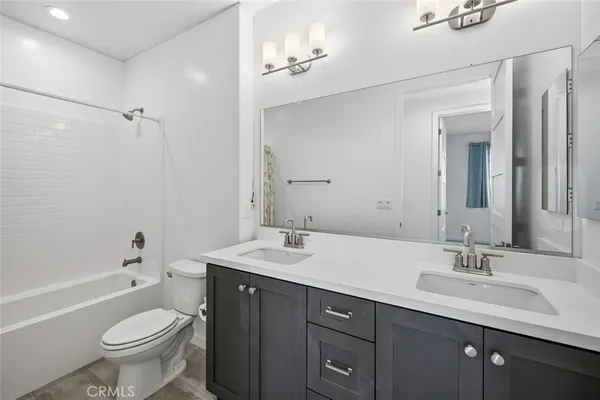 a bathroom with a toilet a sink a mirror a bathtub and vanity