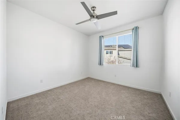 an empty room with windows and ceiling fan