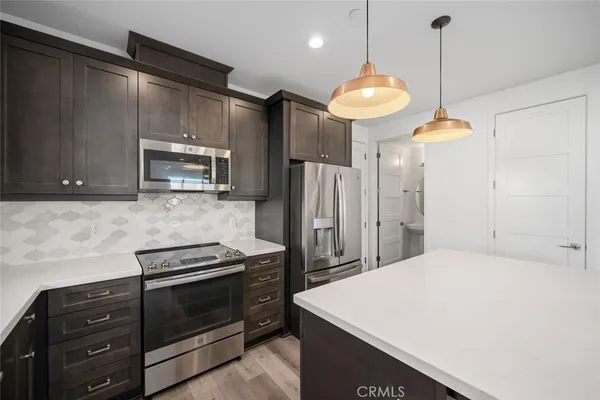 a kitchen with a refrigerator a microwave a stove and cabinets