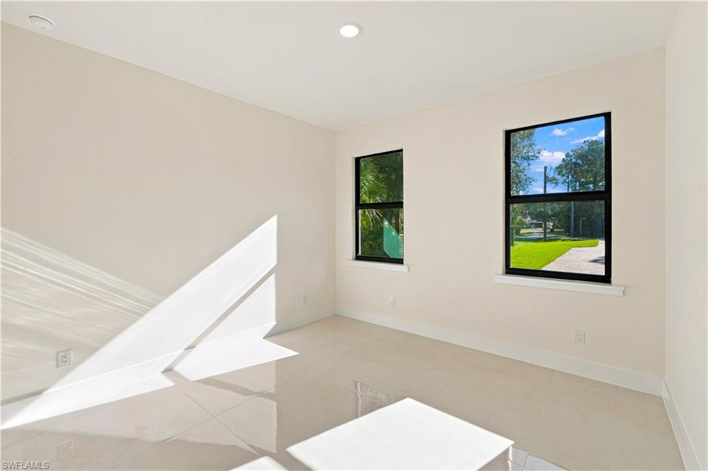 183 5th Street Southwest Naples, FL 34117 - Photo 17 of 40 Recessed ceiling lighting, two windows with black frames, white walls, light-toned tile flooring, and white baseboards