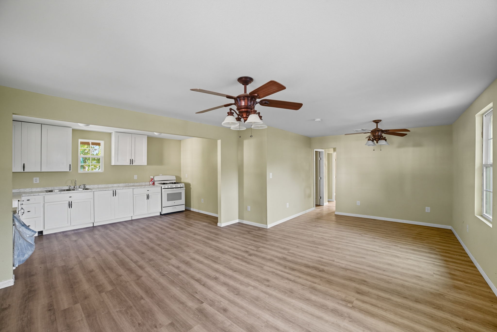 a view of a kitchen with wooden floor and a ceiling fan