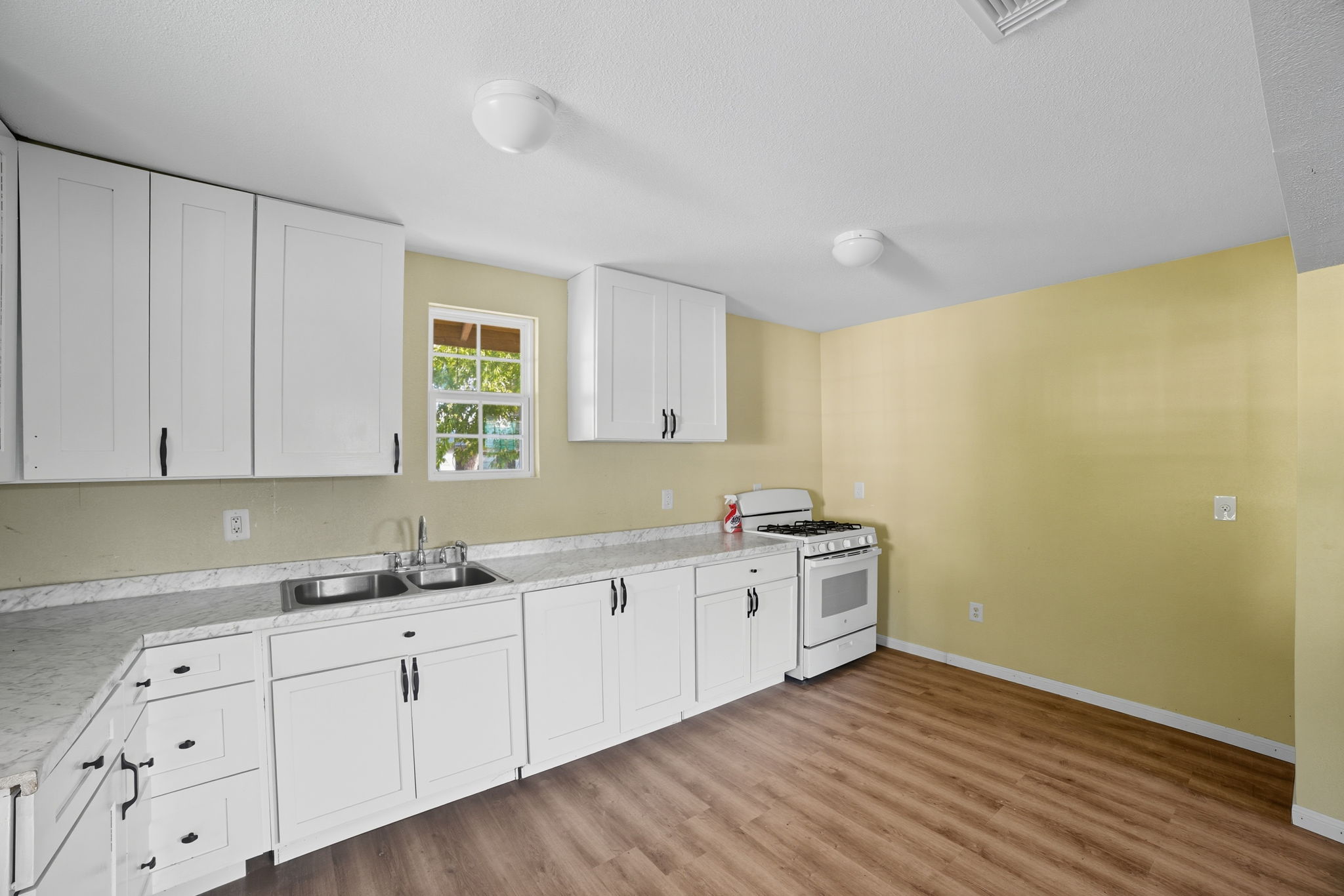 1413 South 2nd Street Temple, TX 76504 - Photo 16 of 24 a kitchen with sink cabinets and wooden floor