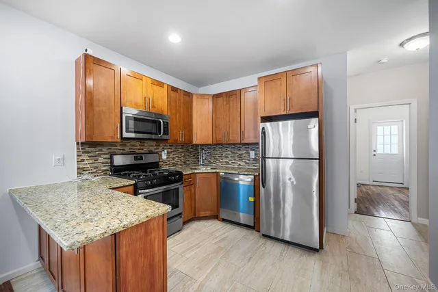 a kitchen with stainless steel appliances granite countertop a refrigerator microwave stove sink and cabinets