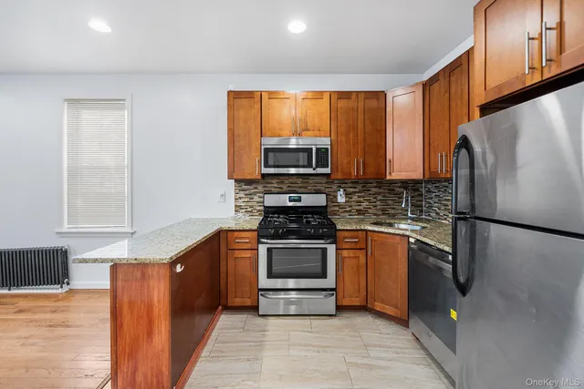 a kitchen with granite countertop a refrigerator stove and microwave