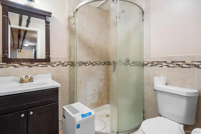 a bathroom with a sink a toilet a mirror and shower