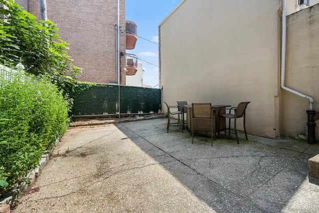 a view of a patio with a table and chairs and potted plants