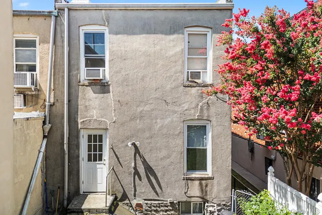 a front view of a house with a tree