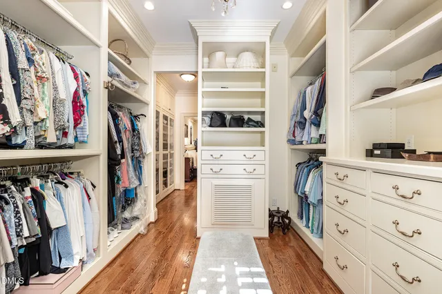 a view of walk in closet with clothes and shoes