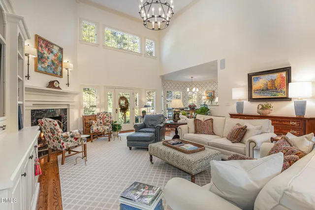 a living room with furniture a chandelier and a fireplace