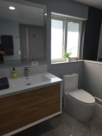 a bathroom with a granite countertop sink toilet and mirror