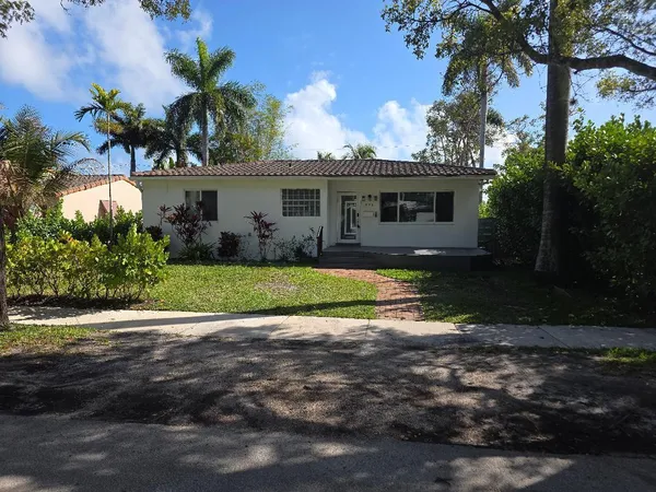 a view of a yard in front of a house with a large tree