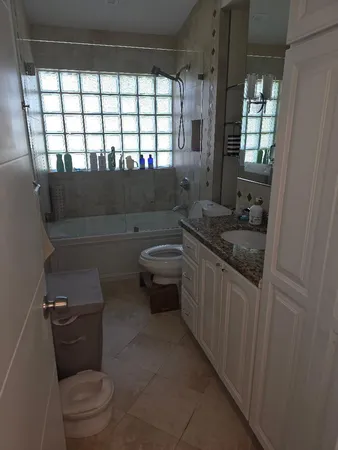 a bathroom with a granite countertop toilet a sink and a bathtub