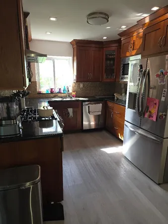 a kitchen with stainless steel appliances granite countertop a sink stove and cabinets