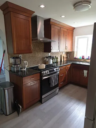 a kitchen with stainless steel appliances granite countertop wooden cabinets a sink a stove a refrigerator and dishwasher