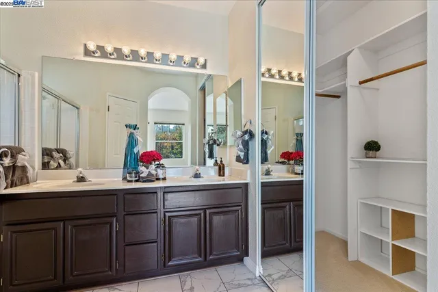 a en suite bathroom with a double vanity sink and a mirror