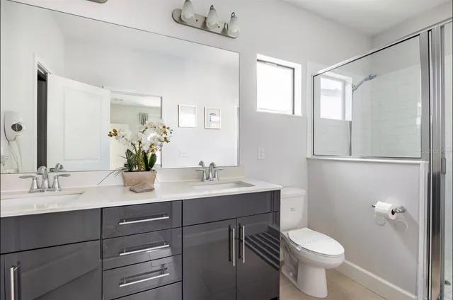 a bathroom with a sink toilet a mirror and shower