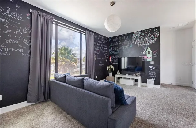 a living room with furniture a flat screen tv and a large window