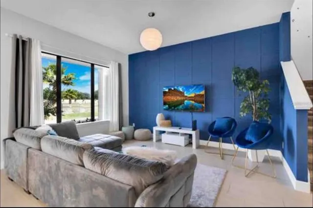 a living room with furniture potted plant and a large window