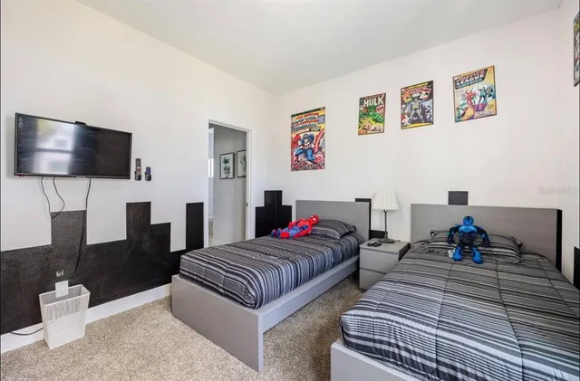 a living room with two beds and a flat screen tv