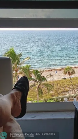 a living room with a floor to ceiling window and outdoor space