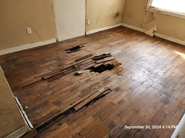 a view of a room with wooden floor and windows