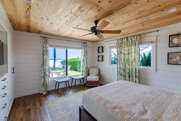 a spacious bedroom with a bed and a chandelier