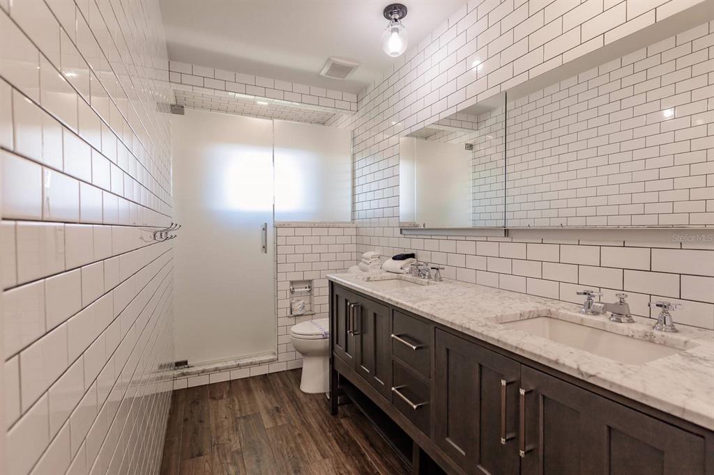 6020 Midnight Pass Road, Unit 26 Sarasota, FL 34242 - Photo 16 of 25 a bathroom with a granite countertop sink a toilet and mirror
