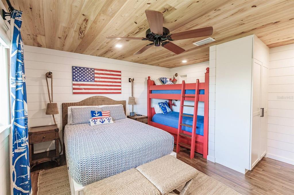 6020 Midnight Pass Road, Unit 26 Sarasota, FL 34242 - Photo 19 of 25 a bedroom with a bed and a chandelier