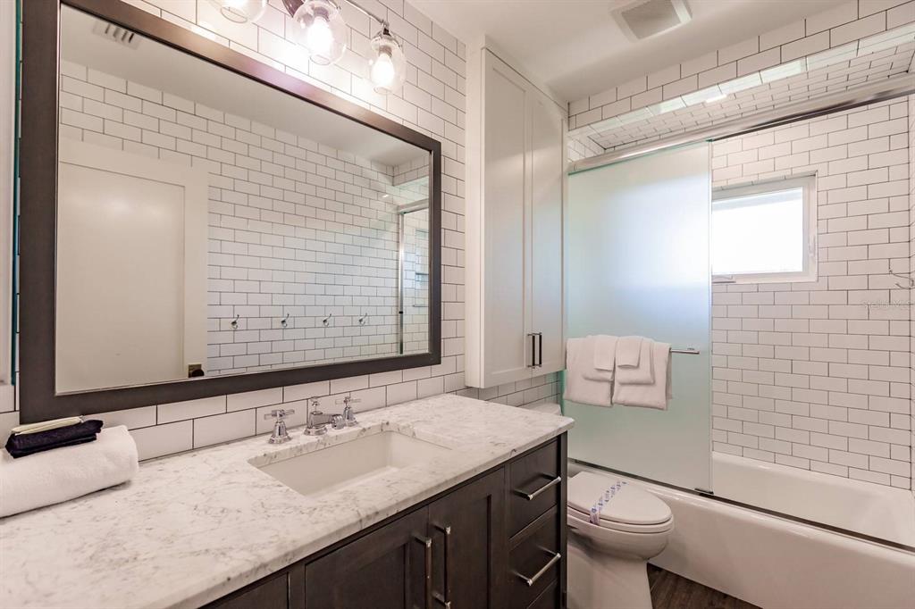 6020 Midnight Pass Road, Unit 26 Sarasota, FL 34242 - Photo 20 of 25 a bathroom with a granite countertop sink toilet and mirror