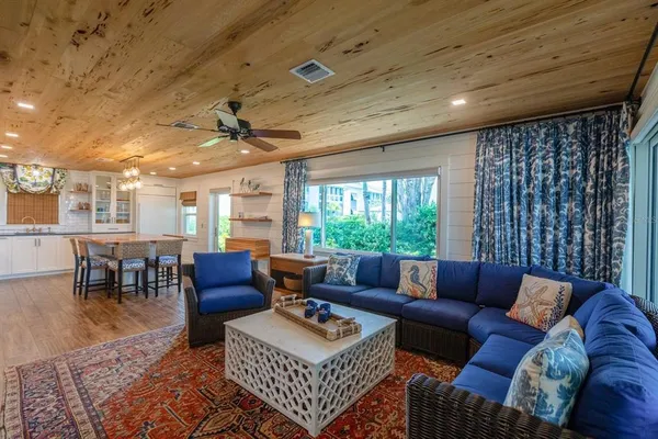 a living room with furniture a table and a large window