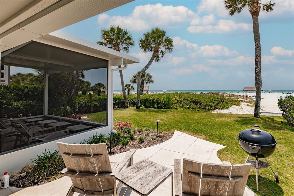6020 Midnight Pass Road, Unit 26 Sarasota, FL 34242 - Photo 24 of 25 a view of a patio with lawn chairs next to a yard