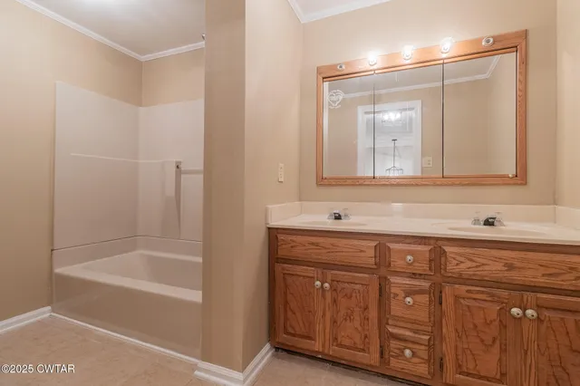 a bathroom with a tub a sink and mirror