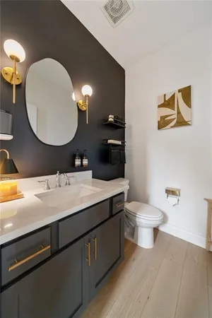 a bathroom with a toilet a sink and mirror