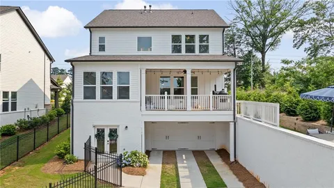 a view of a white house with large windows and a table and chairs